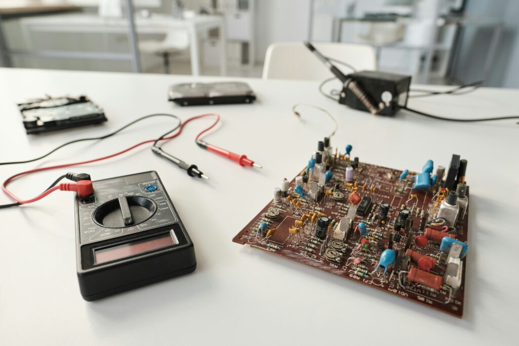 Multimeter testing a circuit board during aircraft electrical maintenance.